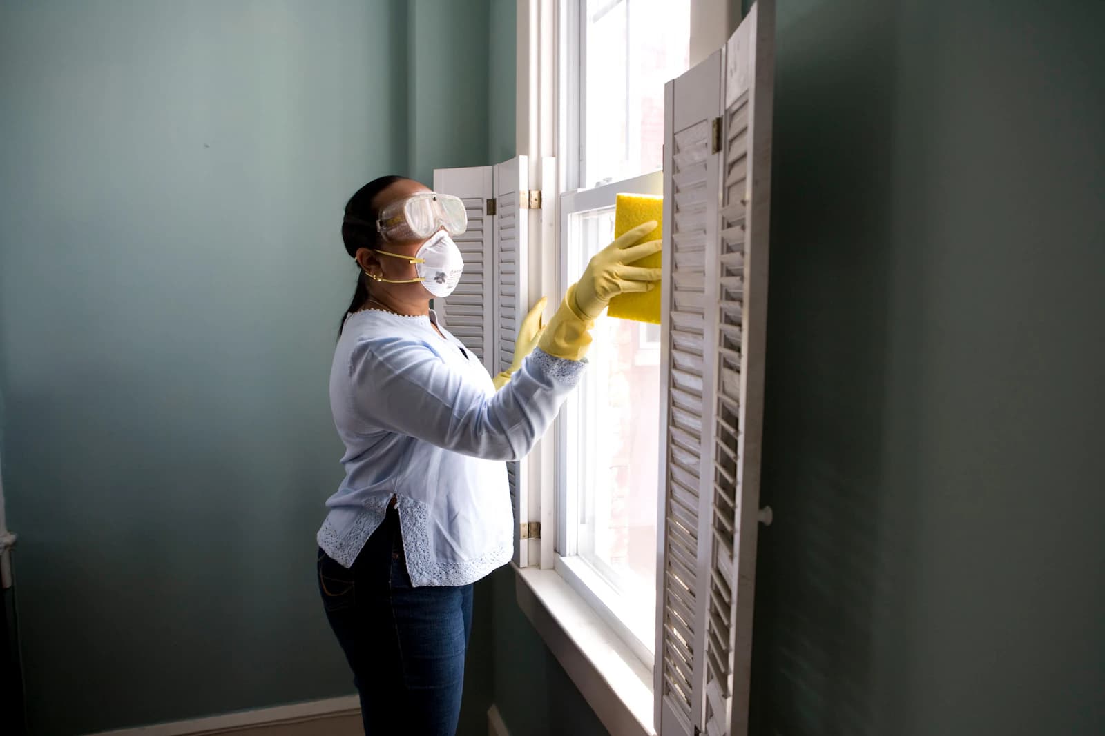 A cleaner wiping down a window